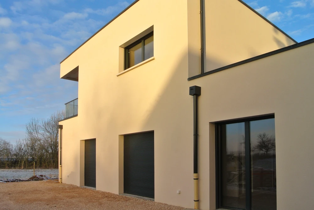 Chantier de rénovation extérieure d'un bâtiment résidentiel avec ouvriers sur échafaudage métallique