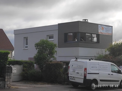 Extension d'une maison de famille, de forme cubique moderne avec un toit plat et de grandes fenêtres et une terrasse